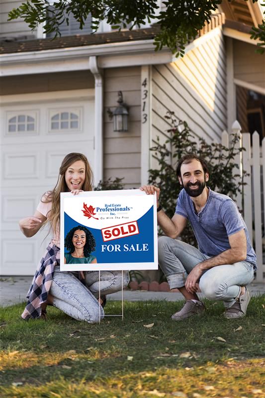 Couple kneeling beside a Real Estate Professionals sold sign